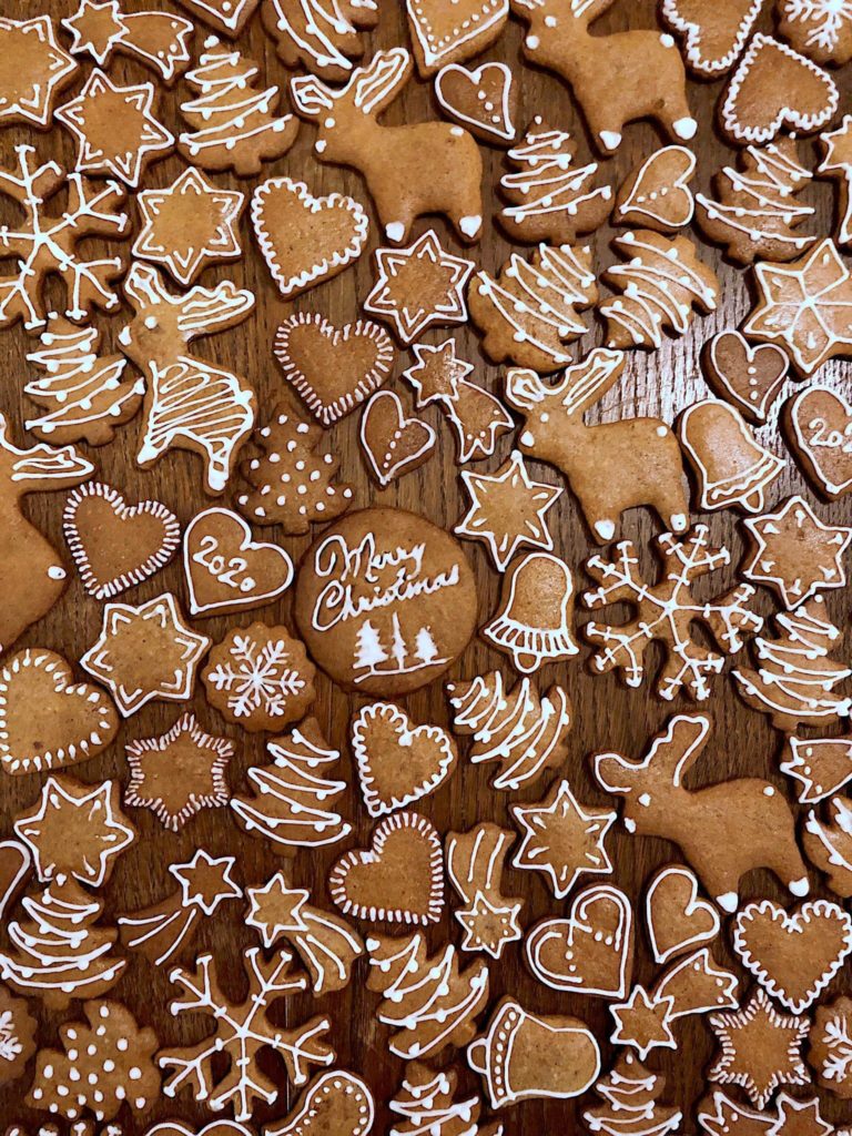 An assortment of gingerbread cookies showcasing various frosting techniques, piping