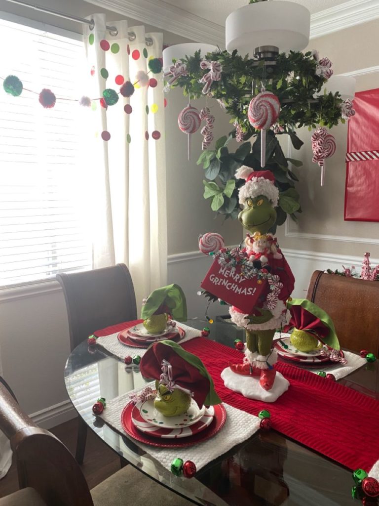 Grinch-inspired Christmas dinner table with green plates, Who-ville napkin decorations