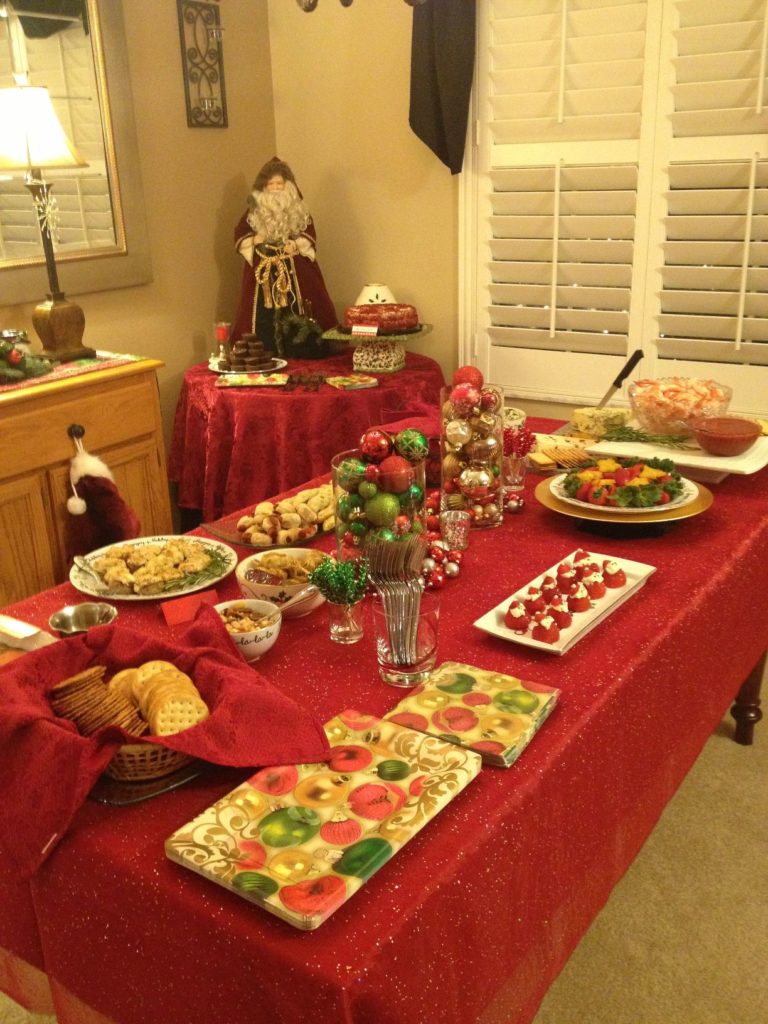 Round platters and bowls filled with Christmas-themed cookies, candies, and treats arranged on a kitchen countertop