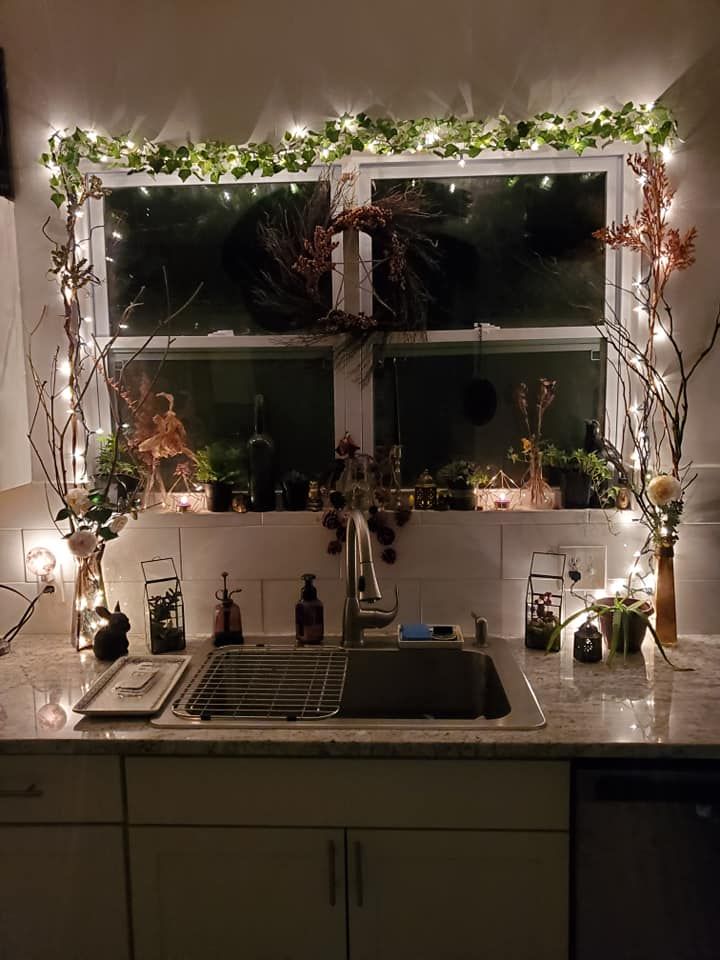 String lights with small white bulbs wrapped around kitchen cabinets, creating a warm and inviting glow.