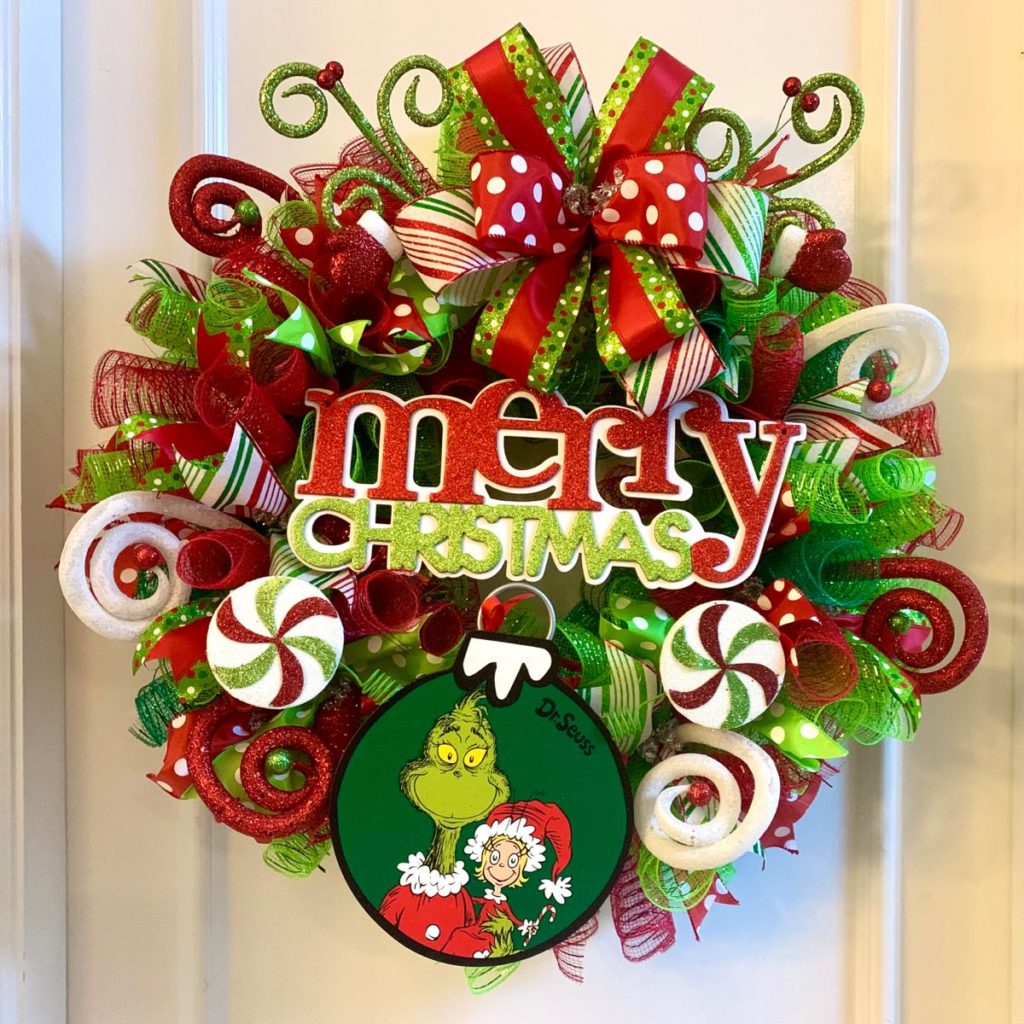 Who-ville-inspired Christmas wreath with yarn base, miniature houses, Cindy Lou Who bows, and Mount Crumpit replica.