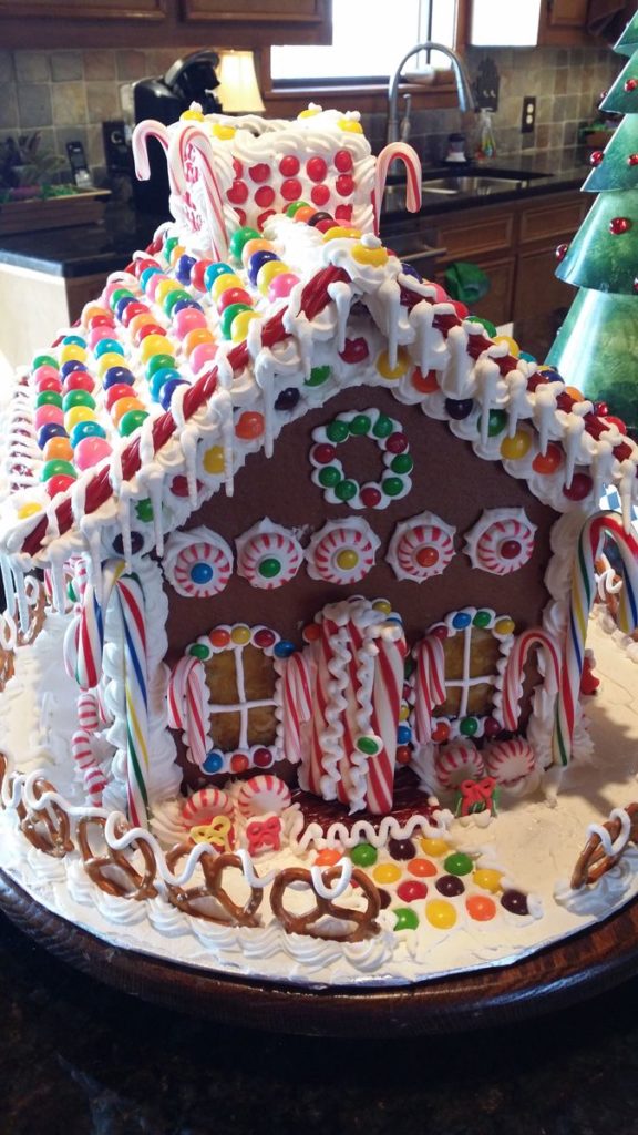 festive gingerbread house adorned with candy canes, gumdrop windows, and a colorful licorice door.